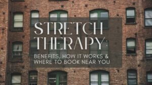 Stretch therapist guiding a client through a leg stretch on a professional table in a wellness studio, illustrating hands-on stretch therapy for improved flexibility, posture, and pain relief.