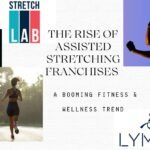 Stretch therapist assisting a client on a padded table inside a modern wellness studio, showcasing the rise of assisted stretching franchises focused on mobility, pain relief, and preventive care.